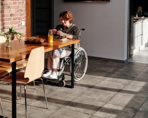 woman-sitting-on-wheelchair-by-the-wooden-table-4064552-1024x683